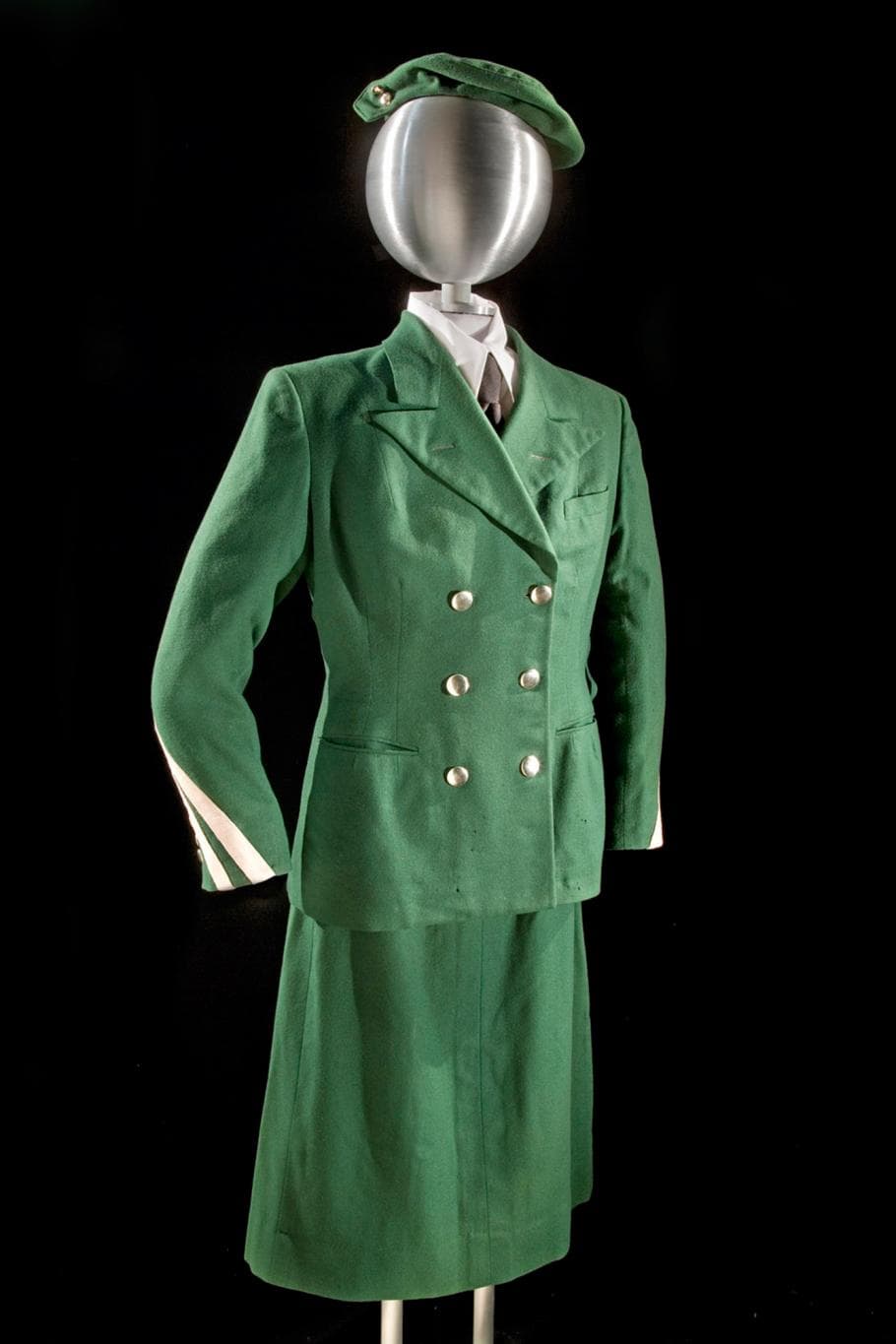 a green flight attendant uniform on a metallic bust